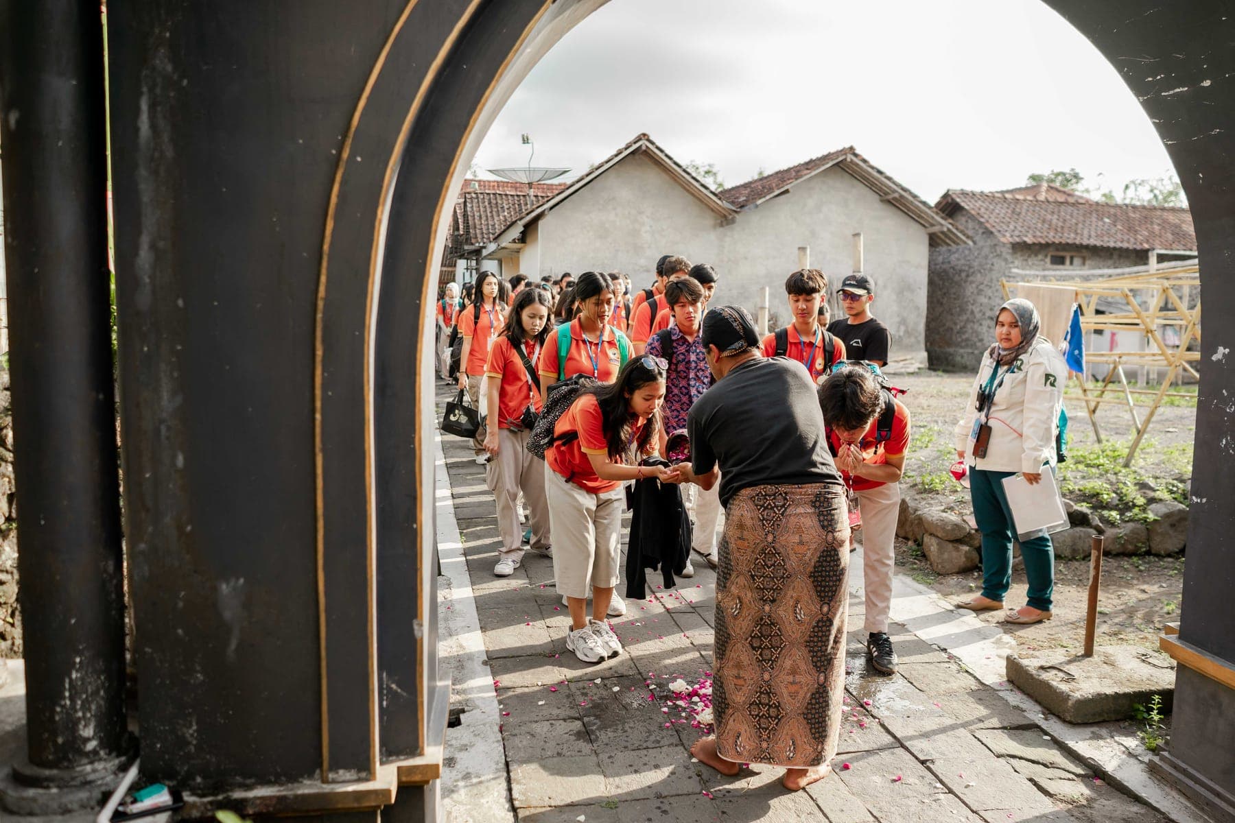 Rombongan siswa berseragam berjalan beriringan bersama guru pendamping di area terbuka