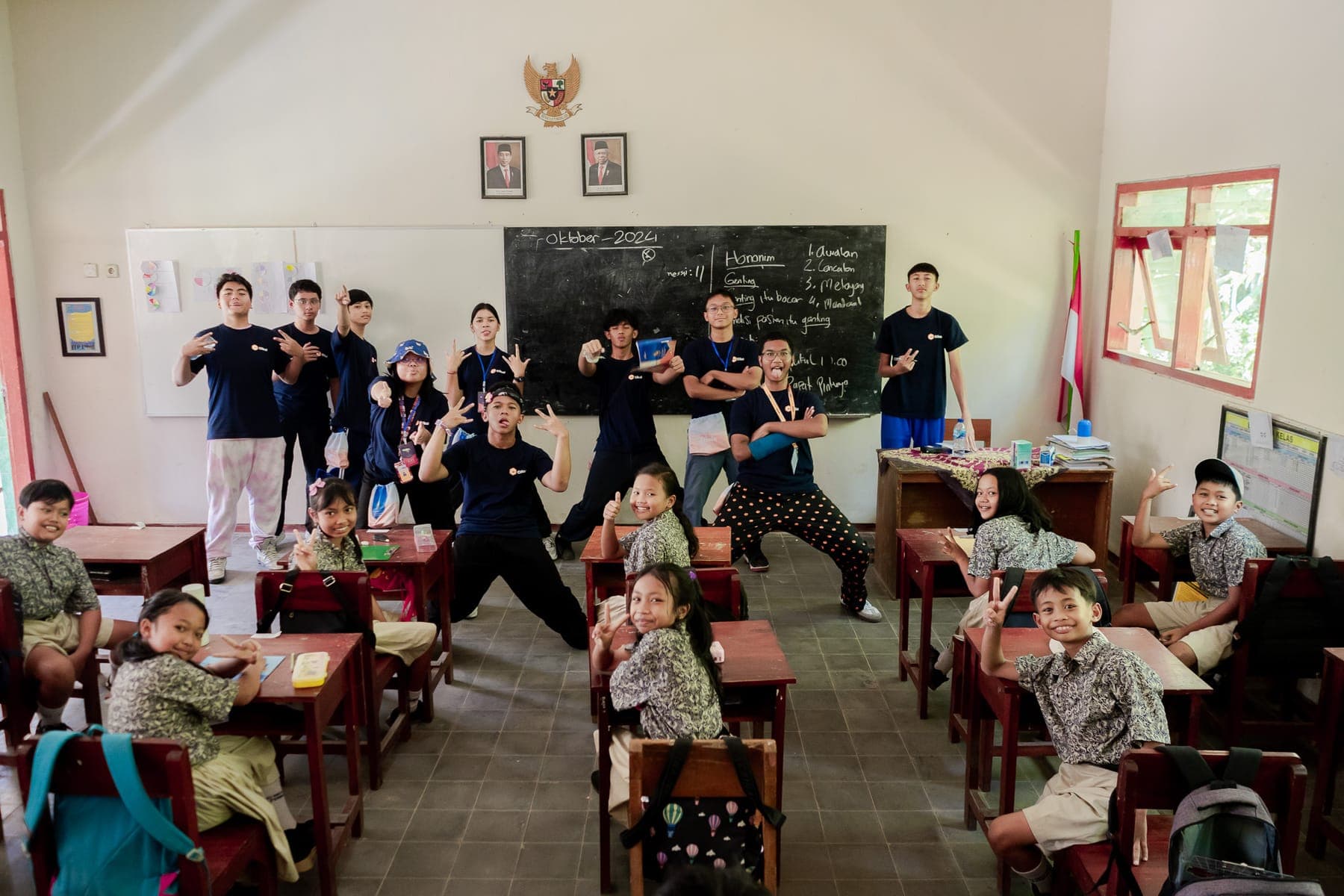 Rombongan siswa berseragam turun dari bus di lokasi kunjungan sambil membawa tas ransel