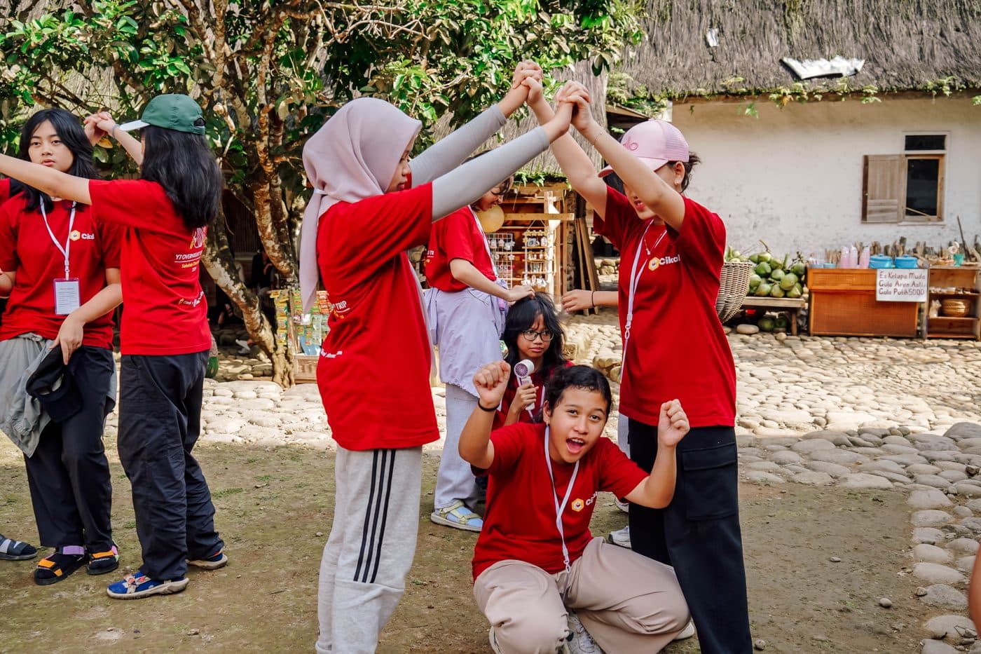 Sekelompok remaja berkaos merah saling bertepuk tangan tinggi sambil tertawa setelah menyelesaikan sebuah tantangan