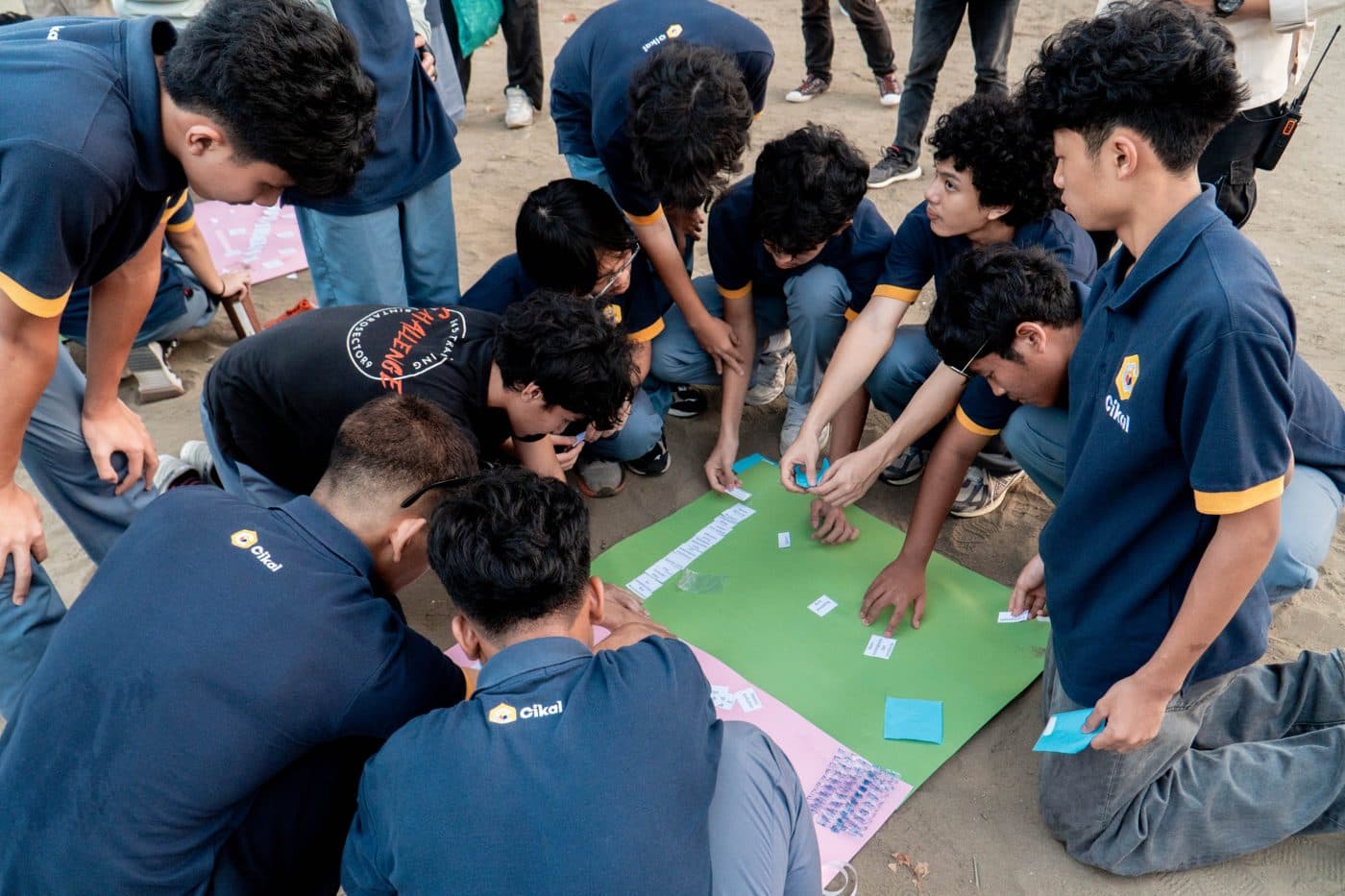 Sekelompok peserta berkumpul rapat membentuk lingkaran sambil berdiskusi sebelum memulai aktivitas